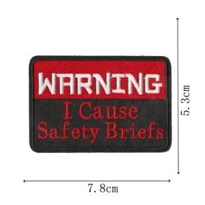 Détail de patch brodé tactique montrant un design d'avertissement rouge avec bordure propre.