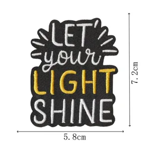 Close-up detail of embroidered patch featuring motivational slogan text and size measurements.