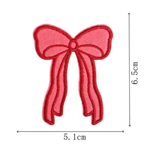 Detailed close-up of pink embroidered bow patch, showing red stitching and exact dimensions.