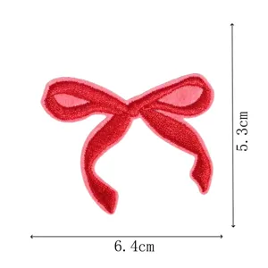 Detailed shot of the red embroidered bow patch showing fine stitching and clear size.
