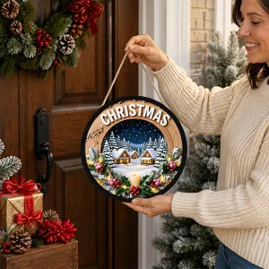 Christmas LED hanging sign detail showing glowing cabins and snow scene in warm holiday setting.