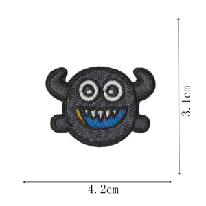 Close-up detail of a cute black monster embroidered patch with horns, size 4.2x3.1cm.