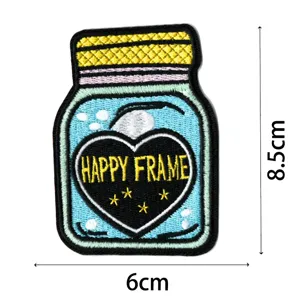 Détail de patch brodé en forme de pot avec cœur et étoiles, idéal pour réparation DIY.