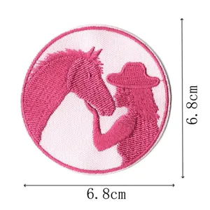 Pink cowgirl horse embroidered patch detail, cute cartoon fabric accessory closeup view.