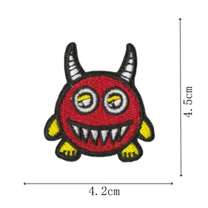 Red cartoon monster embroidered patch, cute devil DIY apparel accessory detail view.