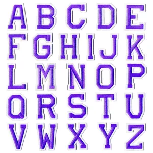 Gros plan sur les ecussons lettres alphabet brodes violet, decoration vetement DIY style.