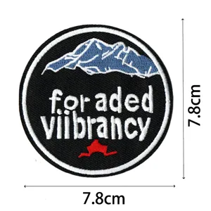 Close-up detail of the round embroidered mountain patch showing fine stitching texture.