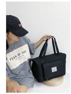 Foldable black travel duffel bag detail, portable fitness gym bag with front pocket.