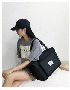 Detailed view of black travel duffel bag, showing durable fabric and front pocket design.