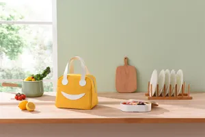 Gele geïsoleerde lunchtas met schattig smiley-ontwerp, ideaal voor school, werk of dagelijkse maaltijden.
