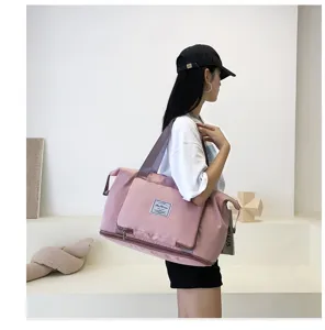 Pink travel duffel bag side view showing large capacity and shoulder strap details.