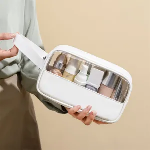 Clear waterproof PVC cosmetic bag with white PU leather trim and handle for travel storage.