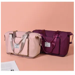 Foldable travel duffel bag detail, featuring dual handles and front pocket storage.