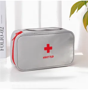 Gros plan détaillé du sac de premiers secours gris avec tissu résistant et croix rouge.