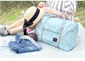 Bolsa de viaje plegable de nailon con bolsillo frontal, ideal para viajes y actividades.
