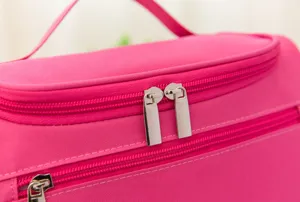 Detailaufnahme des pinken Kosmetiktaschen-Reißverschlusses, wasserdichter Nylonstoff, glatt.