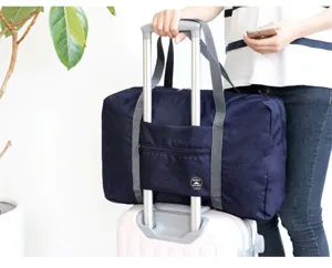 Detalle de bolsa de viaje de nylon con gran capacidad, correa para maleta y bolsillo frontal.