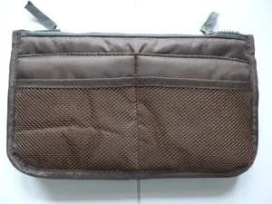 Detailed view of the brown organizer bag with mesh pockets, zippers, and multi-compartments.