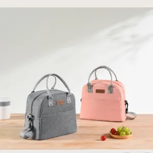 Detail shot of insulated lunch bag in grey and pink with front pocket and durable handles.