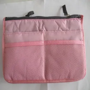 Pink multi-compartment insert organizer handbag with dual zippers and mesh pockets.