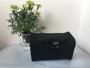 Detailansicht der schwarzen Kulturtasche mit wasserdichtem Material und robusten Reißverschlüssen.