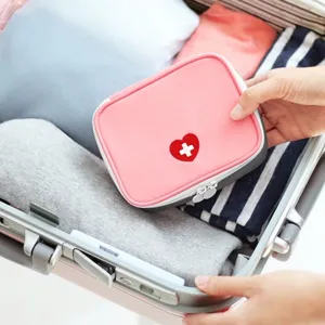 Portable travel first aid storage bag with cute heart design for medical emergency supplies.
