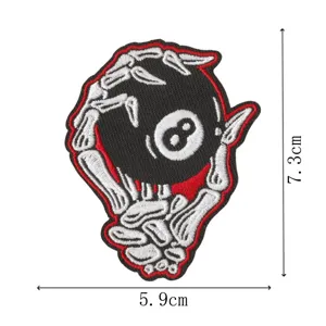 Close-up of a skeleton hand 8 ball embroidered patch, detailed stitching and vibrant red border.