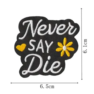 Nahaufnahme Detail des schwarzen bestickten Aufnähers mit weißer Schrift und gelber Blume.