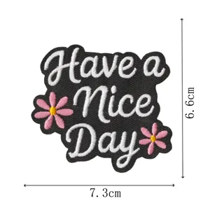 Gestickter Aufnäher Detail mit Text Have a Nice Day und süßem rosafarbenem Gänseblümchen.