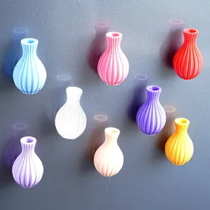 Close-up details of colorful 3D printed vase fridge magnets attached on magnetic metal surface.