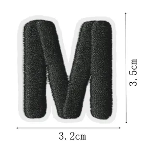 Black letter M embroidery patch detail view, perfect for clothing repair and decoration.