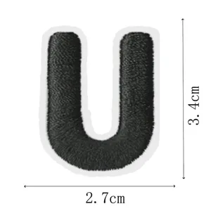 Close-up detail of black embroidered letter U patch showing clear size and texture.