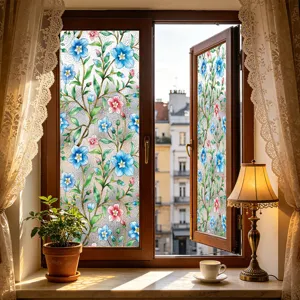 Primer plano de película decorativa para ventana con patrón floral azul en vidrio.