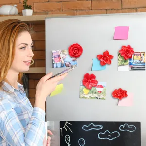 Detailed view of 3D floral fridge magnets attached to a refrigerator surface in a modern kitchen.