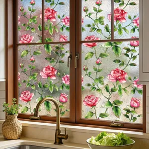 Detalle de película para ventana con diseño de rosas, textura esmerilada y flores coloridas en cocina.