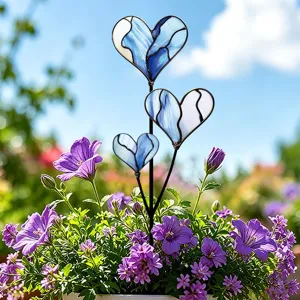 Nahaufnahme von blauen Buntglas-Herz-Gartenpfählen in einem Topfpflanzen-Außenbereich detail.