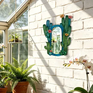 Detailed view of bohemian cactus wall mirror with colorful flower accents hanging on white brick.