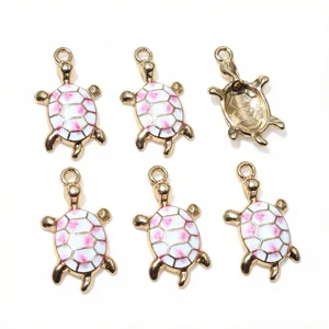 Détail des pendentifs de tortue en émail doré avec jolie coquille rose pour la création de bijoux DIY.