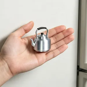 Close-up of a miniature retro kettle fridge sticker displayed on a hand, 3D detail view.
