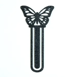 Nahaufnahme des schwarzen Schmetterling Metalllesezeichens mit matter Textur für Bücher.
