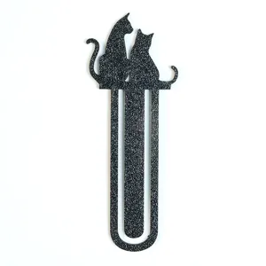 Nahaufnahme eines kreativen schwarzen Katzen Metalllesezeichens, minimalistisches Design.