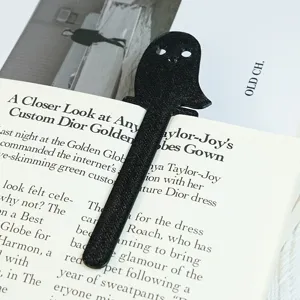 Detaillierte Nahaufnahme eines schwarzen 3D-gedruckten Geister-Lesezeichens im offenen Buch.