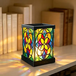Nahaufnahme der Buntglas-Nachtlampe auf dem Tisch mit buntem Blumenmuster und warmem Licht.