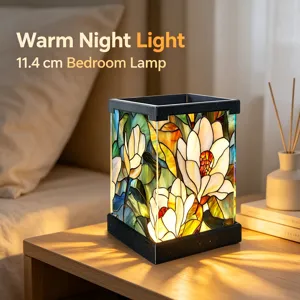 Detailaufnahme einer blumigen LED-Nachtleuchte im Tiffany-Stil auf einem Nachttisch.