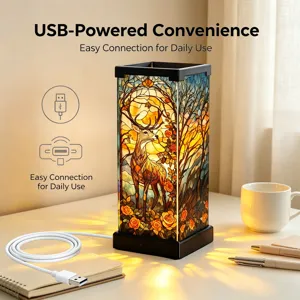 Dettaglio lampada da tavolo in vetro colorato con cervo luminoso e cavo USB sulla scrivania.