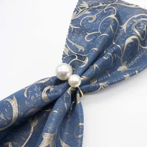 Detail shot of double pearl napkin ring with elegant blue patterned cloth for dining.