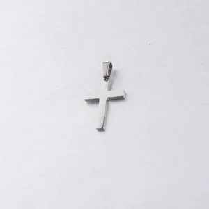 Pendentif croix en acier inoxydable en gros plan, surface polie, idéal pour bijoux DIY.