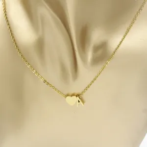 Close-up detail view of gold stainless steel heart and letter A pendant necklace on display.
