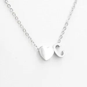 Stainless steel silver color heart and letter C pendant necklace detail close up shot.