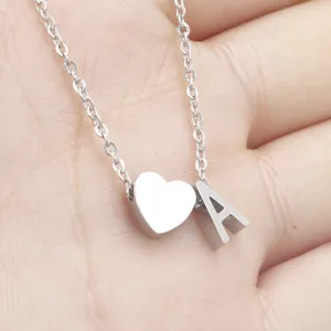 Stainless steel heart and letter pendant necklace close-up detail showing fine chain texture.